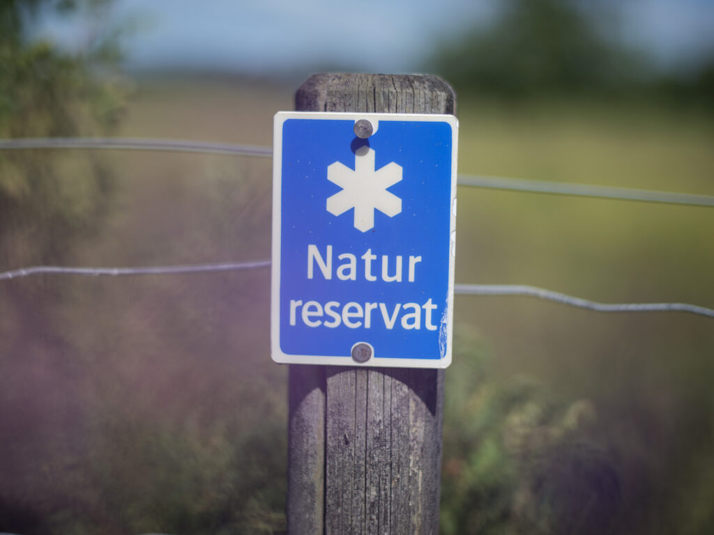 Sign that says "nature reserve" in Swedish. Photo.
